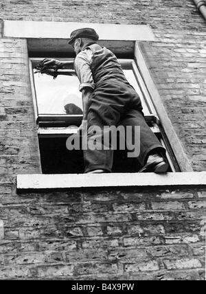 A worried householder understood that sitting on the sill to clean the windows was breaking the law but while the law says nothing about sitting on window sills it does expressly forbid standing on them for the purpose of cleaning or painting unless the windows are those of the basement Stock Photo