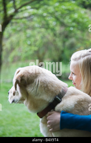 Girl hugging dog in park Stock Photo