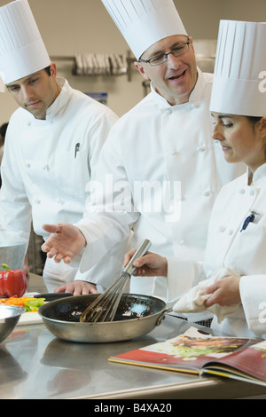 Head chef teaching cooking techniques Stock Photo