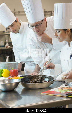 Head chef inspecting cooking techniques Stock Photo