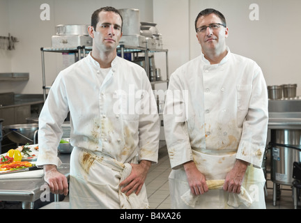 Dirty chefs posing in kitchen Stock Photo