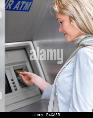 Woman using cash machine Stock Photo