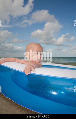 Baby boy sitting in inflatable swimming pool Stock Photo