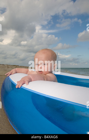 Baby boy sitting in inflatable swimming pool Stock Photo