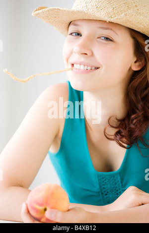 Teenage girl chewing on wheat stalk Stock Photo