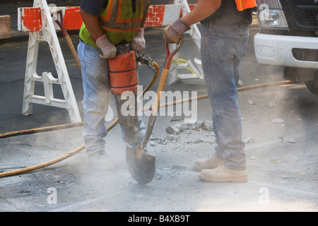 Construction workers using jackhammer and shovel Stock Photo