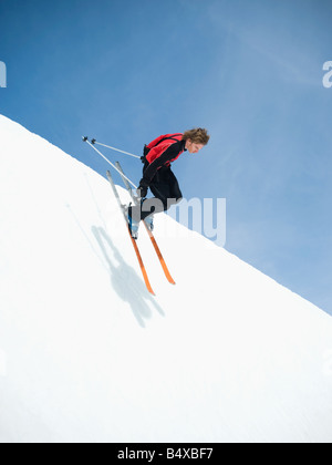 Skier dropping in to half-pipe Stock Photo