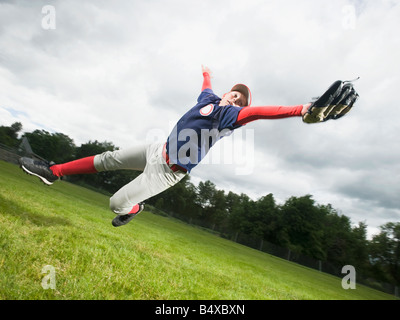 Baseball player diving to catch ball Stock Photo