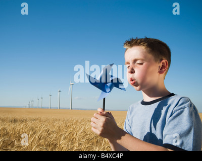 Boy holding pinwheel on wind farm Stock Photo