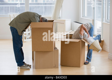 Couple unpacking moving boxes Stock Photo