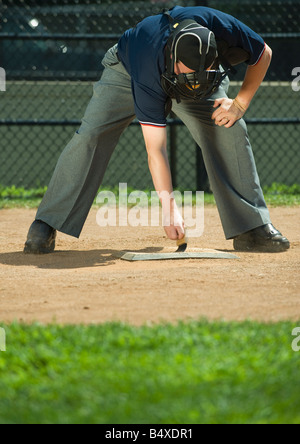 Baseball umpire sweeping home plate Stock Photo