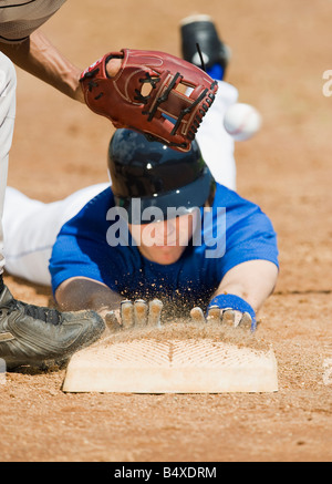 Baseball player sliding into home base Stock Photo