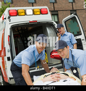 EMTs loading patient into ambulance Stock Photo