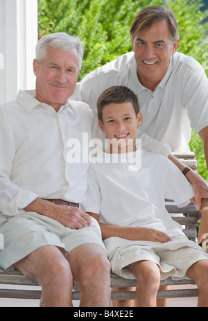 Three generations of men posing on porch Stock Photo