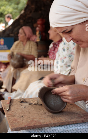A woman working clay to shape a bowl using methods that exist since 1000s of years on Tenerife in the Canary Islands Spain Stock Photo
