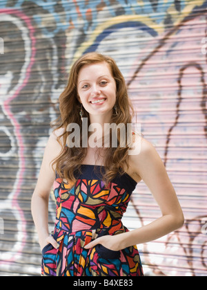 Young woman standing in front of graffiti Stock Photo