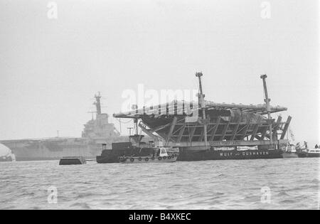 Raising The Mary Rose October 1982 King Henry VIII flagship The Mary Rose on its salvage barge being towed to Portsmouth after being raised from the sea bead of Southsea Seen here passing the airtcraft carrier HMS Bulwark Stock Photo