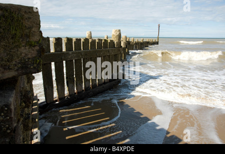 Waves and wooden groynes Stock Photo