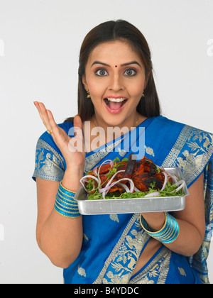 a pretty asian housewife of indian origin with her roasted chicken Stock Photo