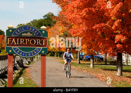 Woman riding bike on Erie Canal bike path in Fairport, NY USA. Stock Photo