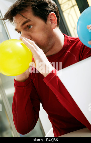 MAN INFLATING BALLOON Stock Photo - Alamy