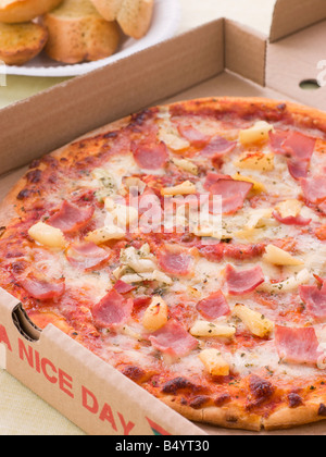 Hawaiian Pizza In A Take Away Box With Garlic Bread Stock Photo