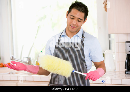 Man Holding Duster And Wearing Rubber Gloves Stock Photo