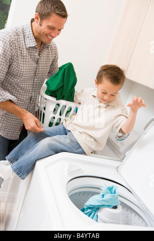 Father And Son Doing Laundry Stock Photo