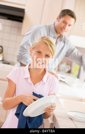 Father And Daughter Cleaning Dishes Stock Photo