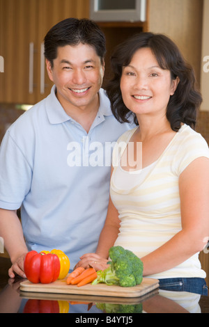 Husband And Wife Preparing Meal Together Stock Photo