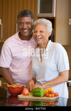 Husband And Wife Preparing Meal Together Stock Photo