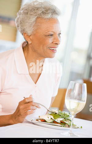 Woman Enjoying Meal With A Glass Of Wine Stock Photo