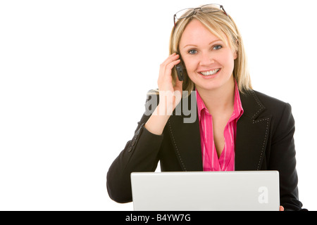 Businesswoman Sitting In Front Of Laptop Talking On Mobile Phone Stock Photo