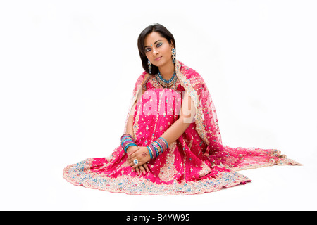Beautiful Bangali bride in colorful dress sitting isolated Stock Photo