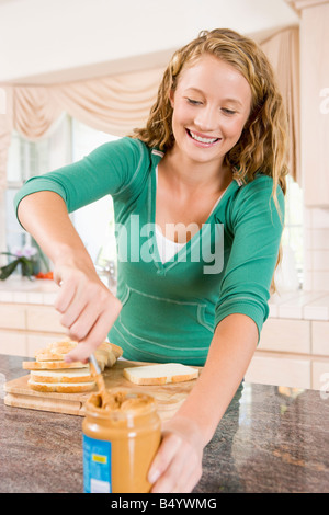 Teenage Girl Making Peanut Butter Sandwich Stock Photo