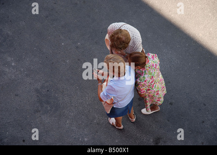 Three elderly ladies looking at a mobile phone, Alicante, Comunidad Valenciana, Spain Stock Photo
