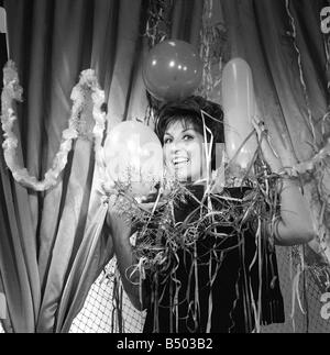 Alma Cogan wraps herself in Christmas decorations at ATV House in Marble Arch London 28 12 61 Born 19th May 1932 Died 26th October 1966 aged 34 British singer of the fifties and sixties Very succesful and popular and acclaimed by one critic as the girl with the laugh in her voice Cogan s main strength was her versatility able to change from one stle of music toanother with consumate ease She was a regular on radio often appearing with the comedian Jimmy Edwards In the sixties her fame died out in the UK but she became immensely popular on the continent and could sing in several languages Stock Photo