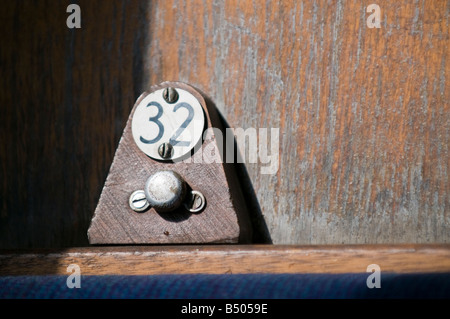 Number 32 seat number peg in old railway carriage Stock Photo