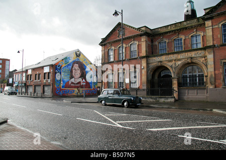 The Bobby Sands mural (on the Sinn Fein head office wall), black taxi & the Belfast Public library on the Falls Road, Belfast. Stock Photo