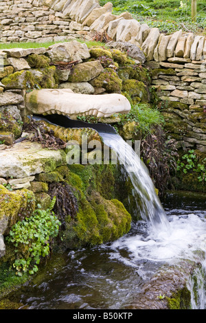 A Cotswold stone conduit in the shape of a crocodile's head in the Cotswold village of Compton Abdale, Gloucestershire. Stock Photo