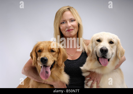 License available at MaximImages.com - Woman with two Golden Retrievers pets dogs care Stock Photo