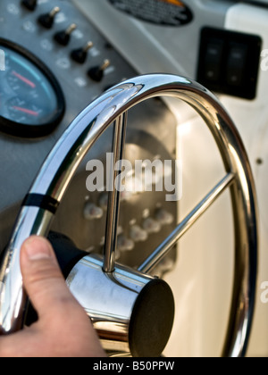 The hand of the ship's captain holding the steering wheel on a boat Stock Photo