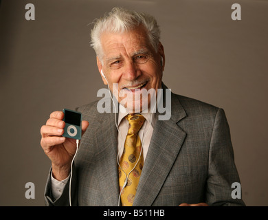 Senior citizen grooving to tunes on an iPod Stock Photo