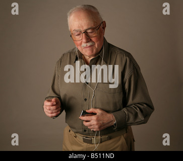 Senior citizen grooving to tunes on an iPod Stock Photo