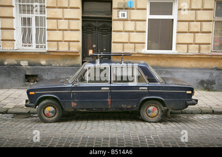 Old dirty dark blue Lada saloon car parked on a cobbled street in Kiev, Ukraine Stock Photo