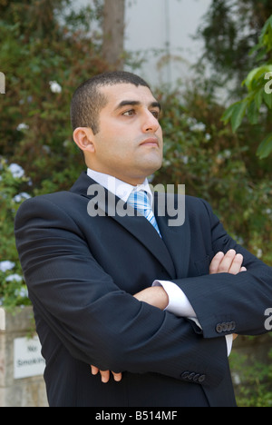 Serious business man arms folded outdoors Stock Photo