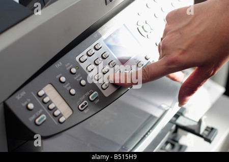 Woman is using a fax machine Stock Photo