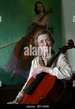Elderly woman cellist with oil painting from her younger years Stock Photo