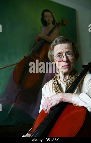 Elderly woman cellist with oil painting from her younger years Stock Photo