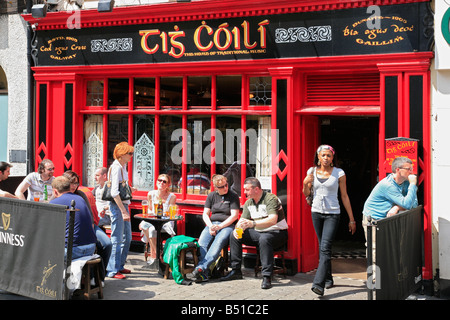 black young woman leaves a Gaelic pub in Galway, Ireland Stock Photo